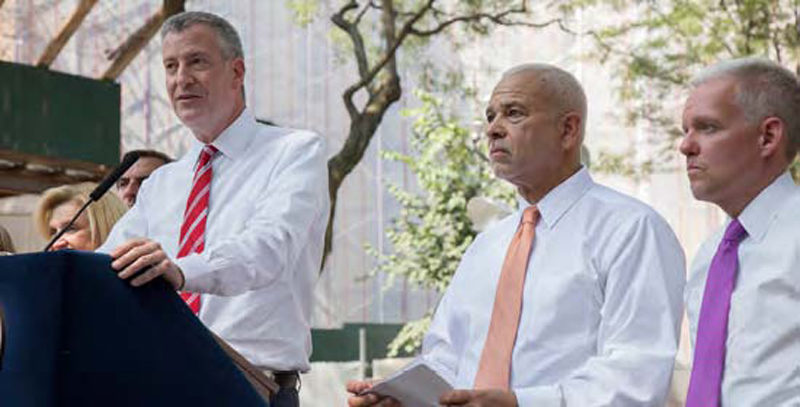 Mayor Bill de Blasio announces the start of the $87 Million Queensbridge Houses roof replacement. To his right are General Manager Michael Kelly and City councilmember Jimmy Van Bramer.