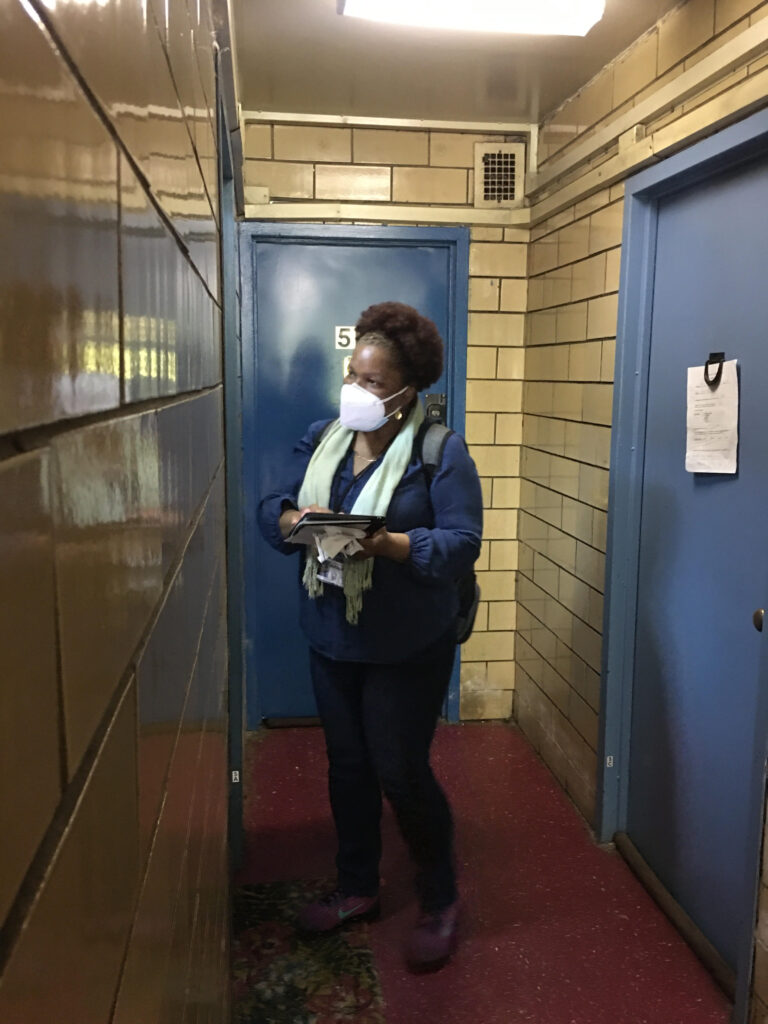 woman standing outside of NYCHA apartment