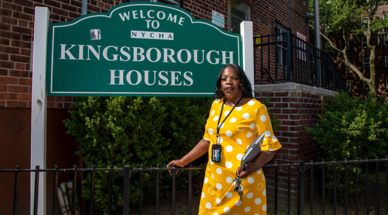 woman in yellow dress standing in front of outdoor sign for Kingsborough Houses