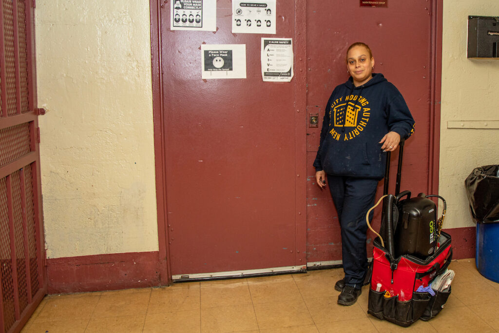 woman wearing NYCHA hoodie standing with extermination equipment