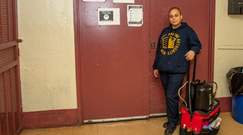 woman wearing NYCHA hoodie standing with extermination equipment