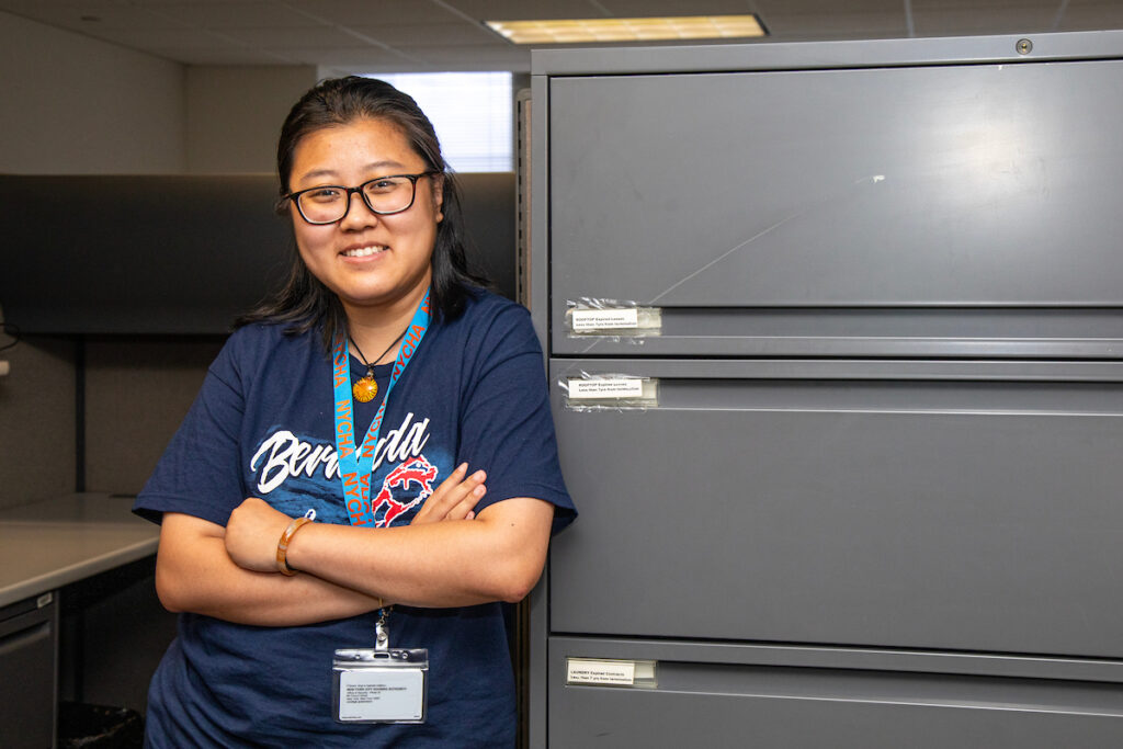 young woman leaning against file cabinet