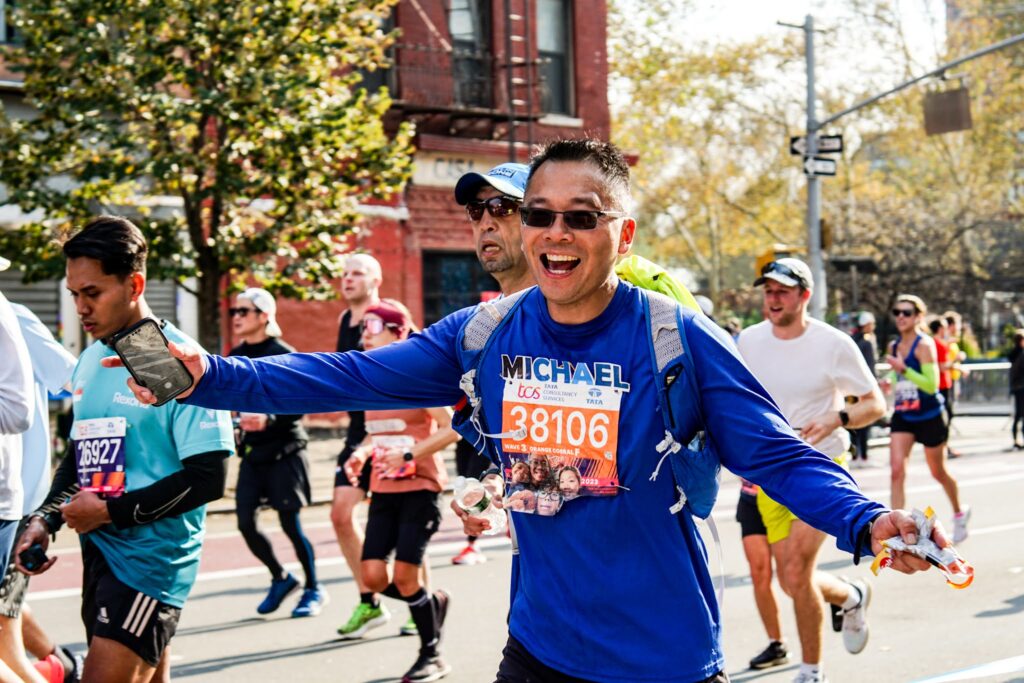 n image of a NYCHA employee posing with their medal after running the 2023 New York City Marathon.