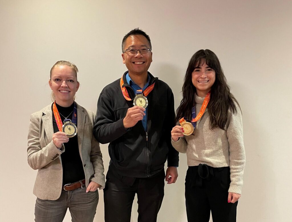 An image of NYCHA employees posing with their medal after running the 2023 New York City Marathon.