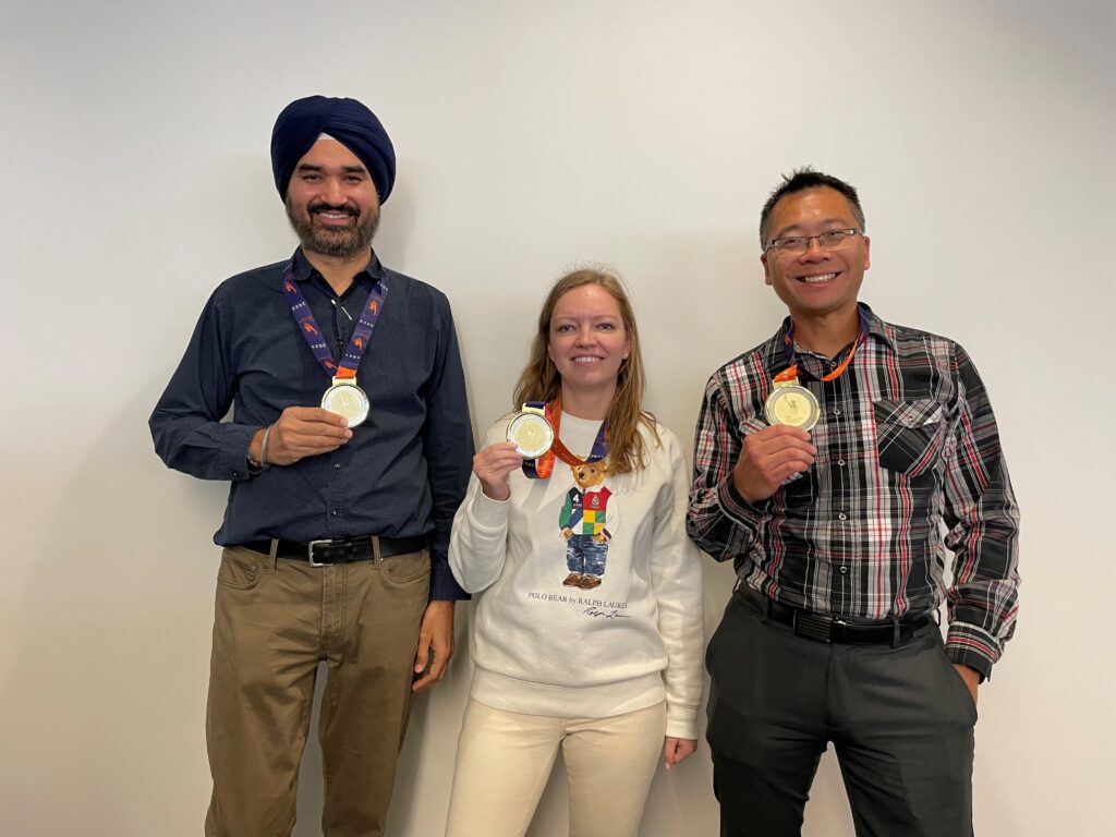 An image of NYCHA employees posing with their medal after running the 2023 New York City Marathon.