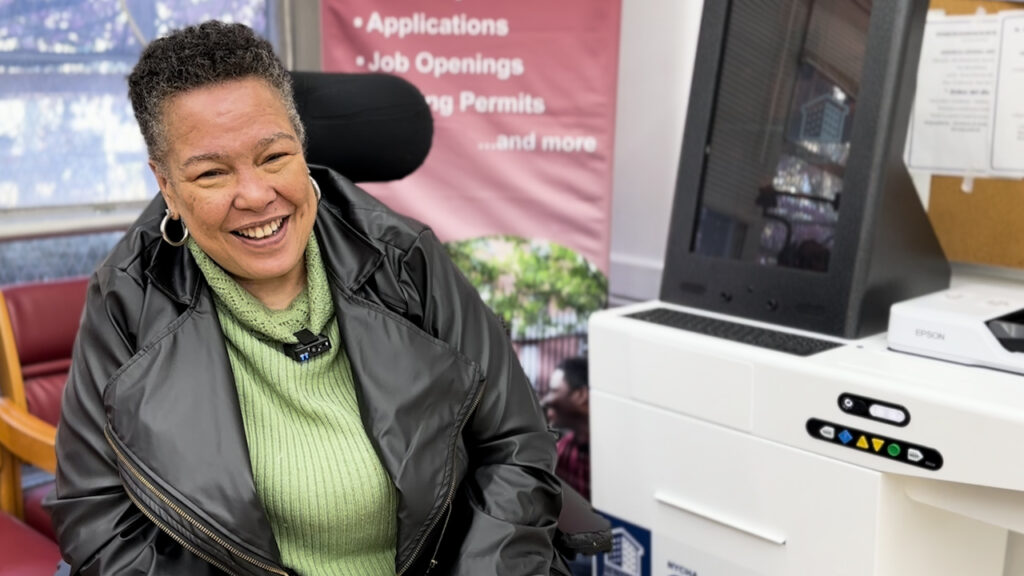 woman in wheelchair in front of self-service kiosk