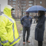 Chair Olatoye tours Sumner Houses with Housing Manager Michael Jones, and along the way stops to talk to Taliea Berry, Caretaker J. Chair's anniversary tour