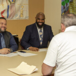 Mike Flores, Assistant Director of the Lead Hazard Control Department, (left) and Marlon Forbes, Deputy Director of the Office of Mold Assessment and Remediation, interview an attendee Job fair