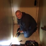 A maintenance worker caulking in an apartment. Note: Photo taken pre-COVID-19.