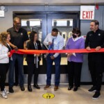 Roland Knight, Senior Program Director for the Miccio Community Center, cuts the ribbon to unveil the upgraded workout room.